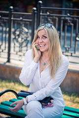 Fototapeta premium blond woman talk by phone outdoor