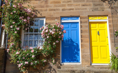Fototapeta na wymiar Colorful cottages with climbing roses