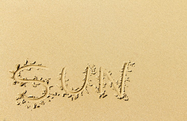 Word sun written on sandy beach