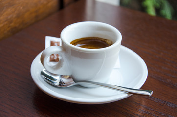 White espresso cup standing on the wooden table