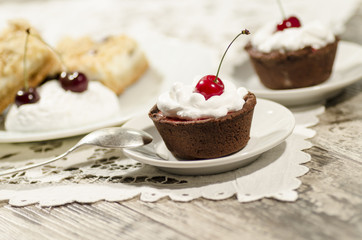 Chocolate dessert decorated with cream and a cherry