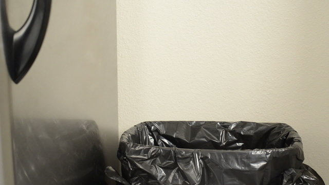 Person throws away beer bottle, no lid on trash