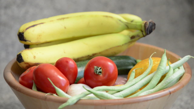 Person picks up zucchini from fresh food bowl