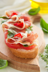 Bruschetta with prosciutto, tomato and basil.