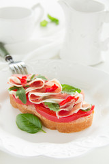 Bruschetta with prosciutto, tomato and basil.