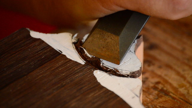 Luthier working with a chisel in a mastil of guitar