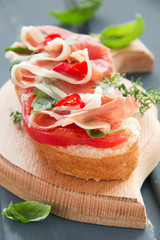 Bruschetta with prosciutto, tomato and basil.