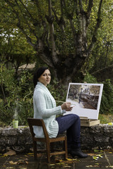 Fototapeta premium young woman painting on a park