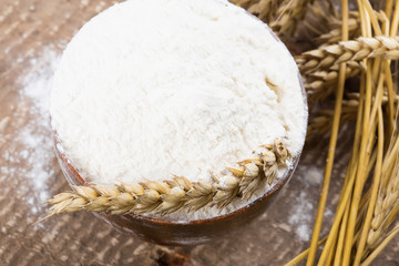 Flour in wooden bowl on table