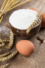Flour in wooden bowl on table