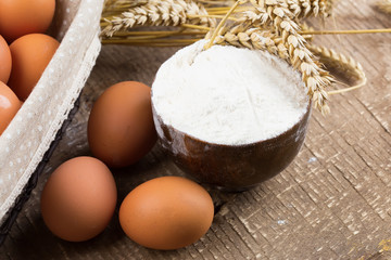 Flour in wooden bowl on table