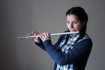 Teenage girl plays the flute. © denys_kuvaiev