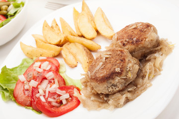 Meatballs with stewed onion and fried potato wedges