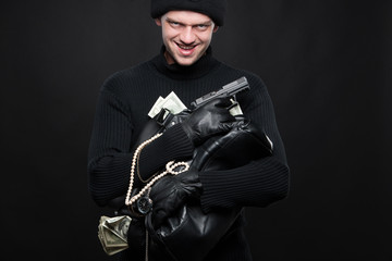 Burglar with stolen goods. Angry burglar holding stolen goods wh