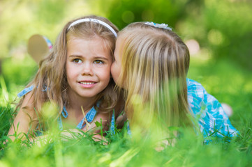 Happy children relaxing on green grass in summer park