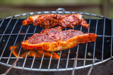 Flames grilling a steak on the BBQ