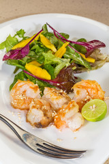 Fresh salad with fried shrimps, variety of salad leafs, mango, o
