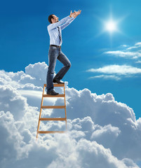 confident businessman high in the sky pulls hands to the sky