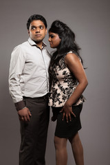 Fashionable passionate indian couple. Studio shot against grey.