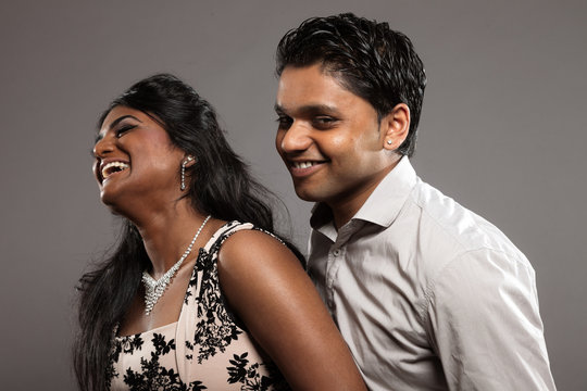 Fashionable passionate indian couple. Studio shot against grey.
