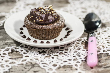 Diet chocolate cupcakes on white plate with pink spoon