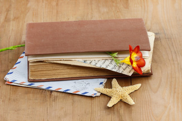 Diary, old letters and red freesia flower on wooden table