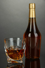 Glass of whiskey with bottle, on dark background