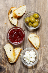 Top view on various appetizers: olives, cranberry, cottage chees