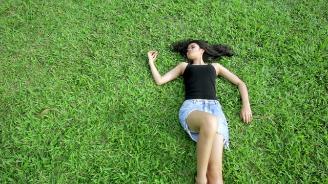 Sexy erotic asian girl with mini skirt on green grass