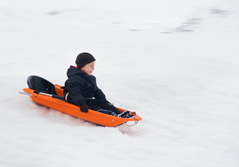 Fototapeta na wymiar boy rides a sled winter