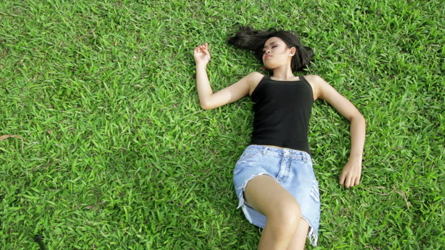 Sexy erotic asian girl with mini skirt on green grass