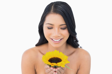 Smiling natural black haired model holding sunflower