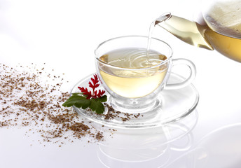 Eingießen von weißem Tee mit Dekoration