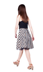 Naklejka premium back view of walking woman in dress.