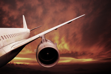 plane is flying at sunset