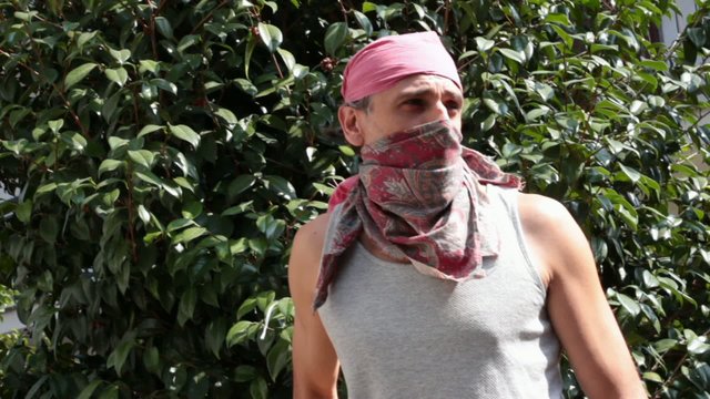 masked man with sling