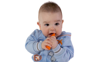 Smiling baby eats carrot