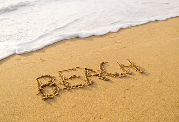 Fototapeta na wymiar Word beach written in the sand beach