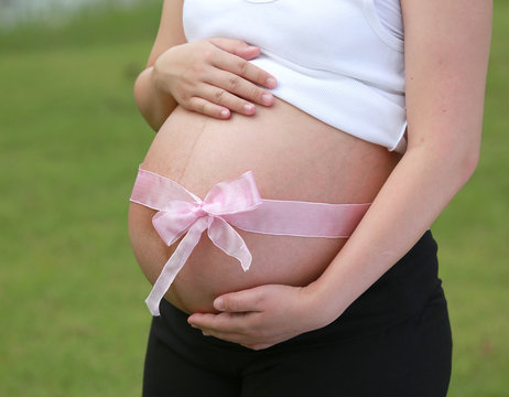Pregnant woman expecting a baby girl at garden