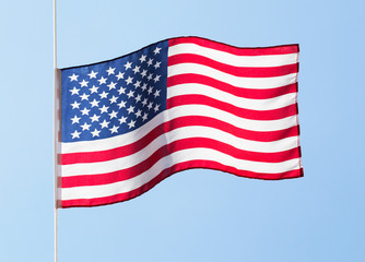 American flag in the wind against a blue sky