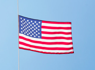 The American flag in the wind against the blue sky