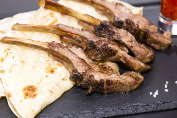 lamb ribs cooked on the grill served on a hot stone