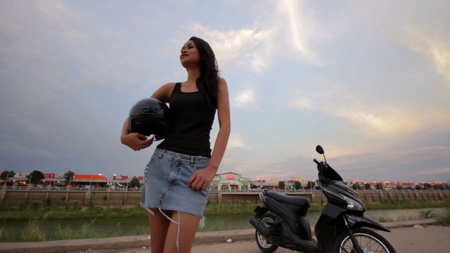 sexy asian girl with mini skirt, helmet, motorcycle in cambodia