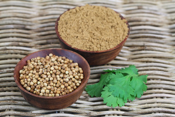 Coriander seeds, coriander powder and fresh coriander on wicker