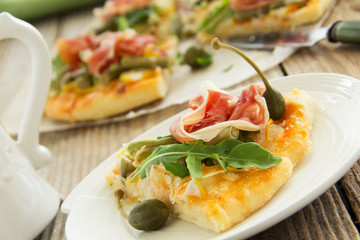 Pizza with arugula and prosciutto.