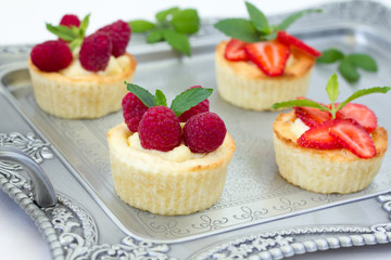 Tartlets with custard and berries on a tray