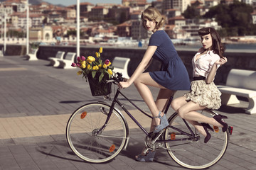 Fototapeta na wymiar two vintage women on bicycle near the sea