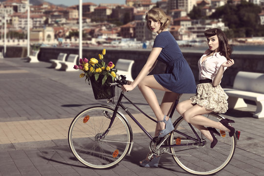 two vintage women on bicycle near the sea