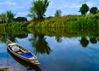 Naklejka na ściany i meble Small boat in a shallow canal