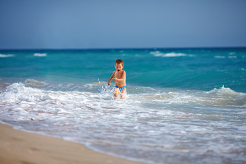 Fototapeta premium happy boy kid having fun in sea water